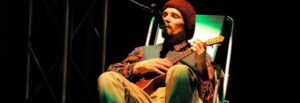 Na zdjęciu aktor Wojciech Chowaniec gra na ukulele i opowiada poetyckie historie.
